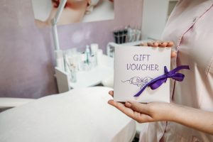 Beauty Salon Gift Certificate. Salon gift vouchers. Cosmetology Gift Card in female hand
